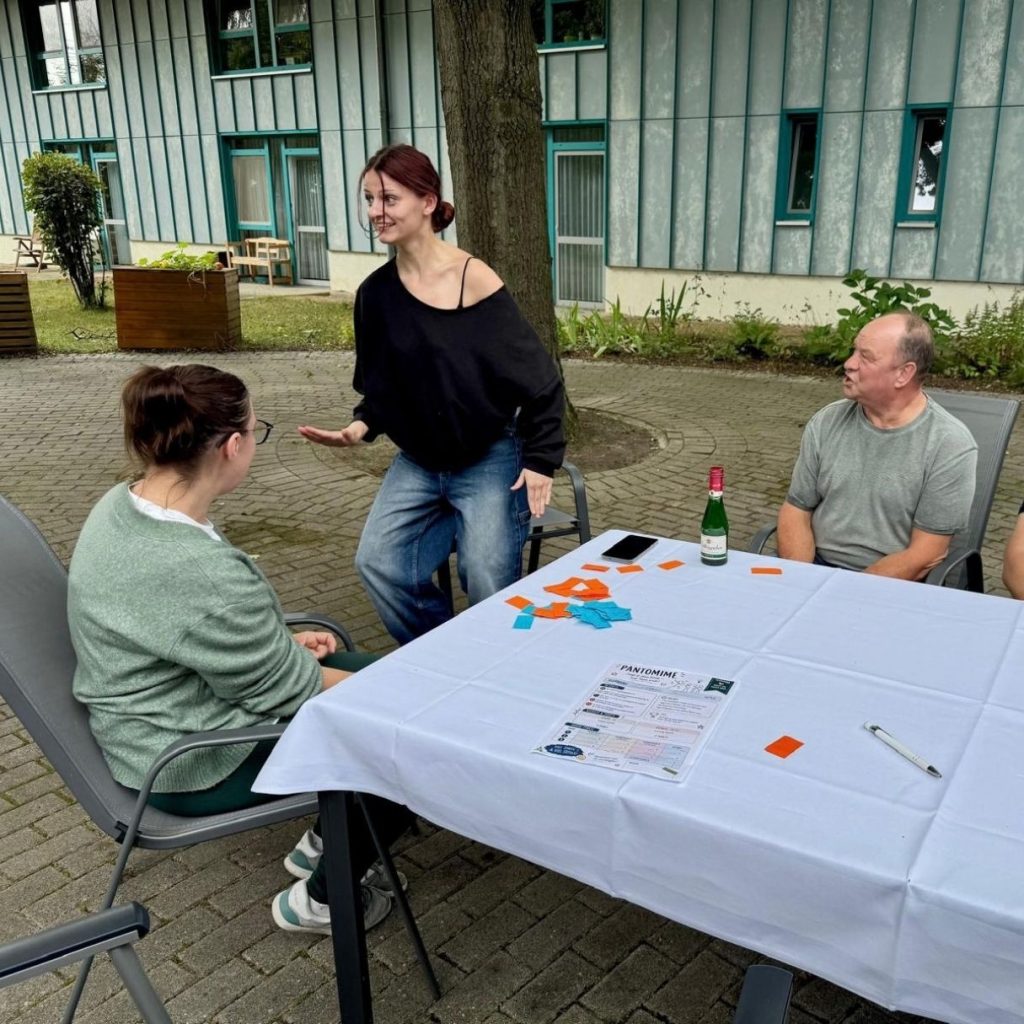 Menschen im Gespräch beim Kartenspielen draußen.