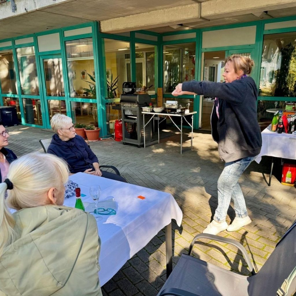 Menschen bei einer Aktivität im Freien vor einem Gebäude.