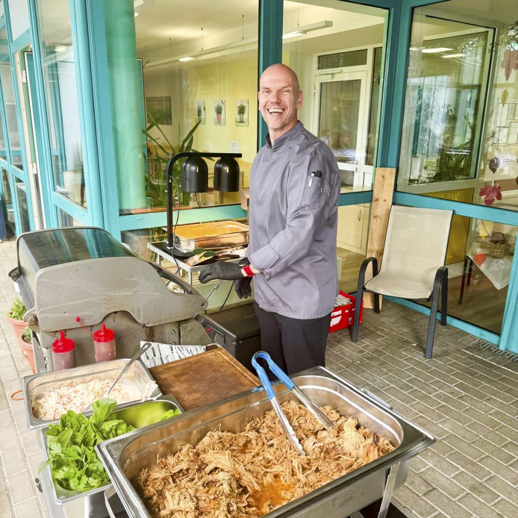Mann in Kochkleidung beim Outdoor-Barbecue